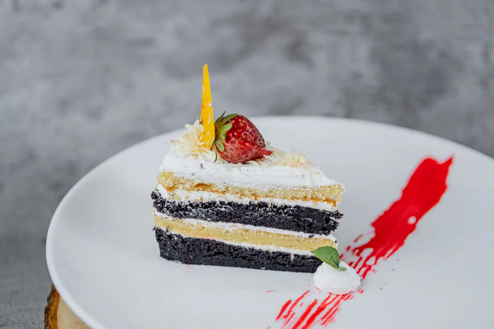 A slice of layered cake with cream between the layers on a white plate